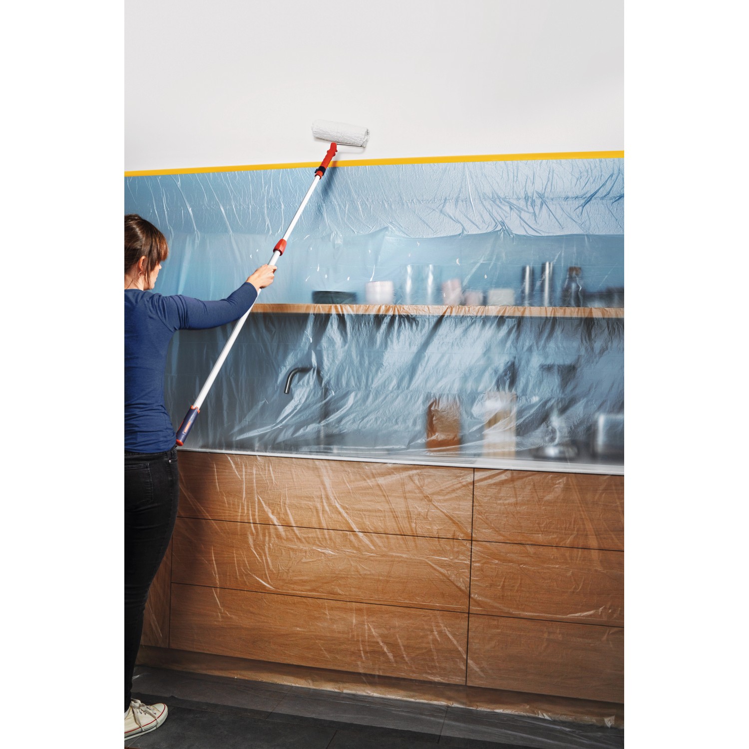 Anwendung der Tesa Abdeckfolie Easy Cover Perfect+ XL beim Malern einer Küche.