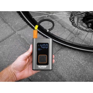 Eufab Mini-Kompressor, aufladbar, in Hand gehalten, mit Fahrradreifen im Hintergrund.