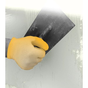 Hand mit gelbem Handschuh glättet weiße Tassullo Klebspachtel mit einer Kelle.