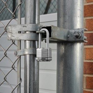 Master Lock Excell Vorhängeschloss aus Stahl, matt, sichert ein Metallgitter.