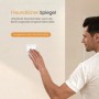 Hand drückt weißen Wandschalter zur Steuerung des Emke Badspiegels mit LED-Beleuchtung und Touchfunktion.