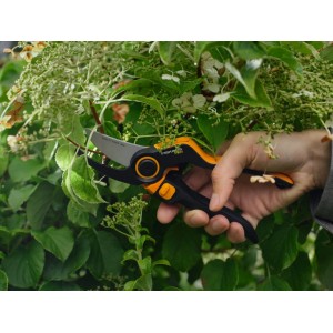 Fiskars Gartenschere Bypass P981 X-Series im Einsatz beim Schneiden von Ästen.