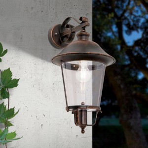Orion Außen Wandleuchte Schwarz-Kupfer im rustikalen Laternen-Design mit klarem Glas an einer Hauswand.