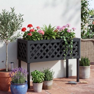 Schwarzes MCW Hochbeet aus Akazienholz mit dekorativem Rankgitter, bepflanzt mit bunten Blumen auf der Terrasse.