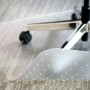 Transparente Bodenschutzmatte 74x120cm mit Noppen unter einem Bürostuhl.