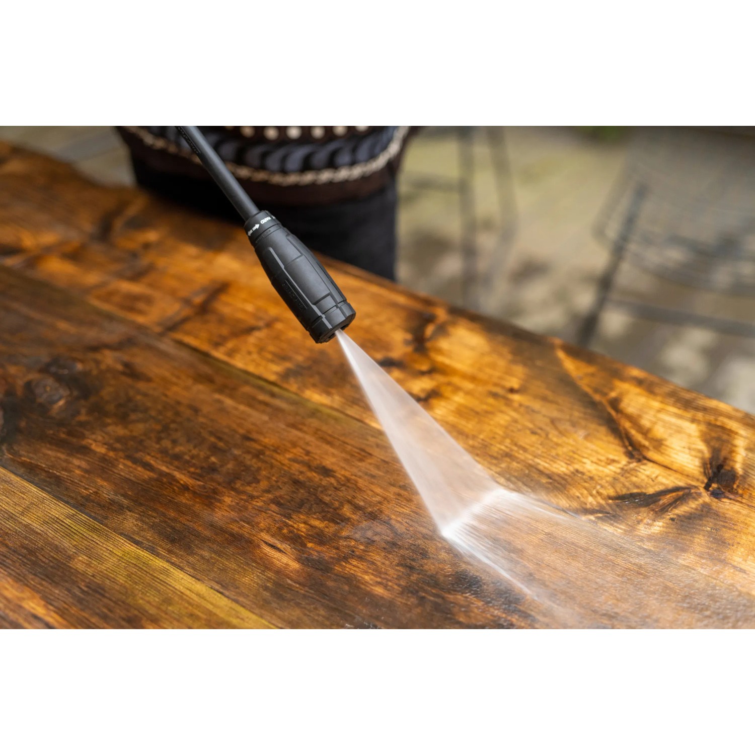 Kärcher Hochdruckreiniger im Einsatz: Reinigung einer braunen Holzoberfläche mit Wasserstrahl.