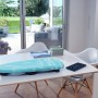 Leifheit AirBoard Compact Tischbügelbrett auf einem Tisch, mit Wäsche und Bügeleisenablage.