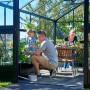 Familie im Juliana Gewächshaus Premium 13 Anthrazit. Das Gewächshaus bietet Platz zum Gärtnern und Entspannen.