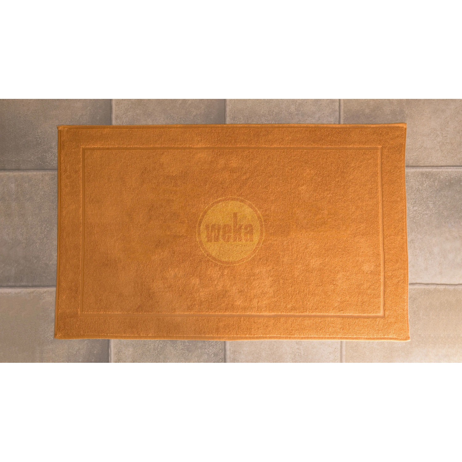 Orangefarbene Badematte mit Weka Logo für die Sauna Kemi.