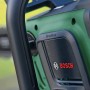 Grüne Bosch Akku-Kettensäge AdvancedChain 36 V. Nahaufnahme des Gehäuses mit 'Brushless' Schriftzug und Bosch Logo.