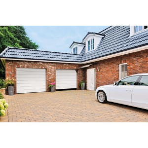 Reinweiße IsoMatic Garagentore mit Antrieb in Hausfassade. Sektionaltore für mehr Platz in der Garage.