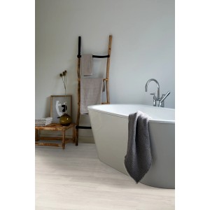 Badezimmer mit hellem Egger Designboden Eiche Weiß Hell und freistehender Badewanne.