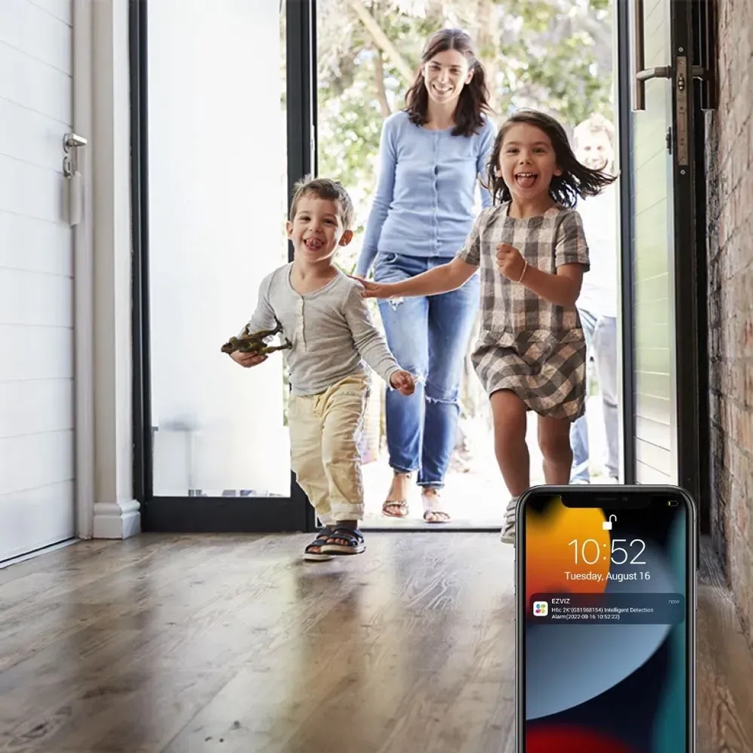 Familie kommt nach Hause, überwacht durch Ezviz Indoor-Überwachungskamera. Benachrichtigung auf Smartphone.