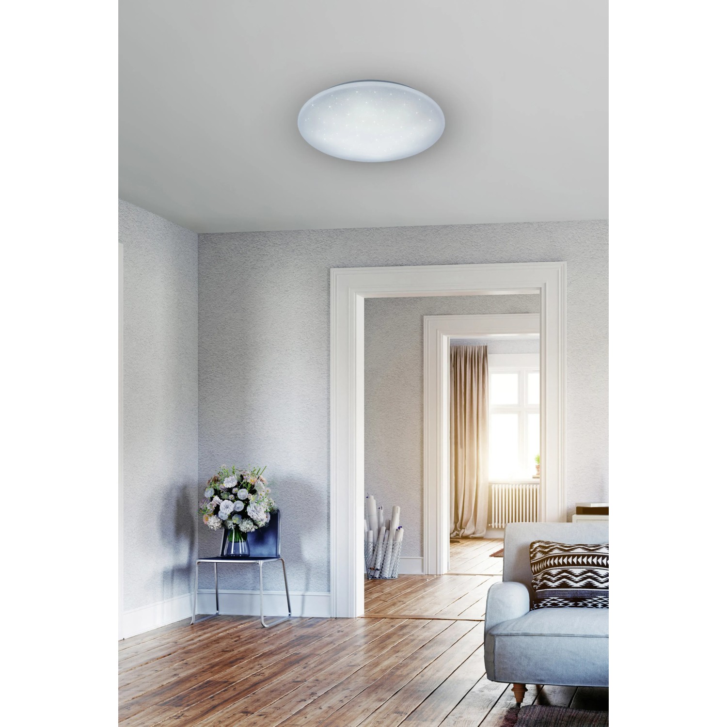 Weiße LED-Deckenleuchte Lukida mit Sternenhimmel-Effekt im Wohnraum.