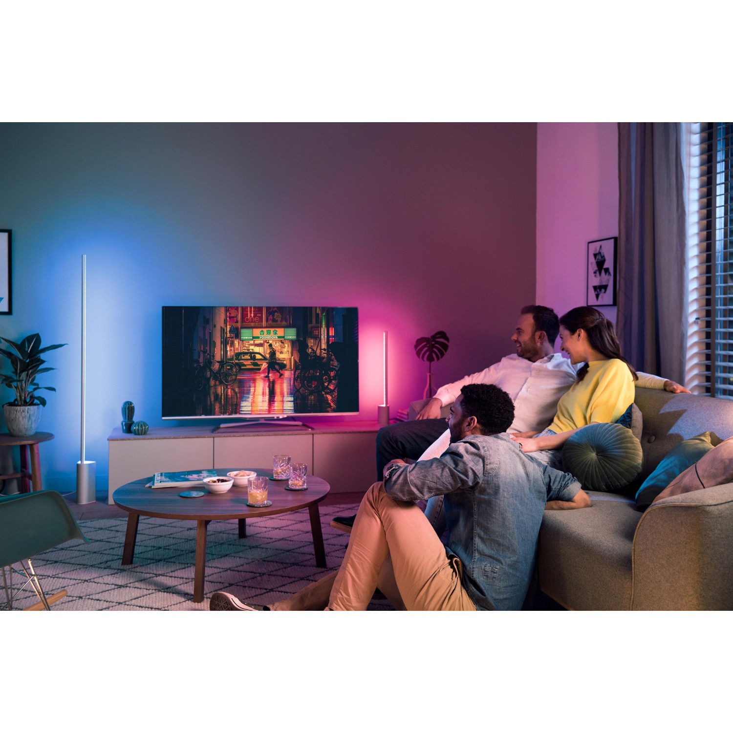 Wohnzimmer mit Philips Hue Gradient Signe Tischleuchte in Weiß, die farbiges Licht ausstrahlt.