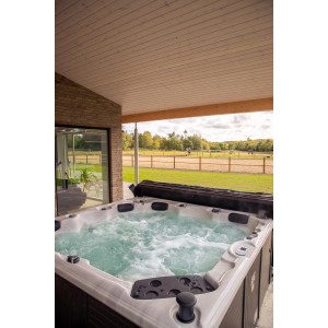 Nordlys Whirlpool Ruby mit 2 Liegen und 4 Sitzflächen im Außenbereich mit Abdeckung.