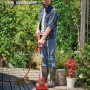 Mann reinigt Holzterrasse mit Einhell Akku-Oberflächenbürste PICOBELLA 18/215. Inkl. Gartenschlauchanschluss.