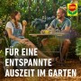 Entspannte Auszeit im Garten mit Compo. Paar sitzt am Tisch, Getränke und Pflanzen.