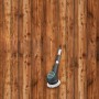 Gardena Tellerbürsten-Aufsatz für AquaBrush Akku-Multi-Reiniger vor Holzwand. Reinigungsbürste mit Nylonborsten.