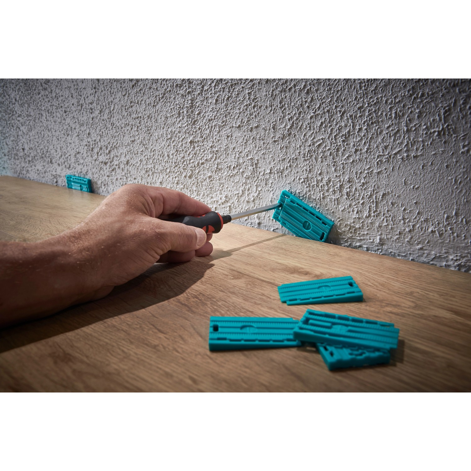 wolfcraft Verlege-Set für Laminat/Designboden mit Zugeisen, Schlagholz und Keilen in Anwendung.