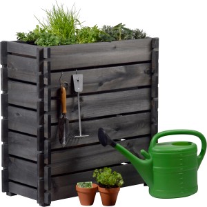 Anthrazitfarbenes Dobar Hochbeet aus Kiefernholz mit Stecksystem, bepflanzt mit Kräutern, mit Gießkanne und Gartengeräten.