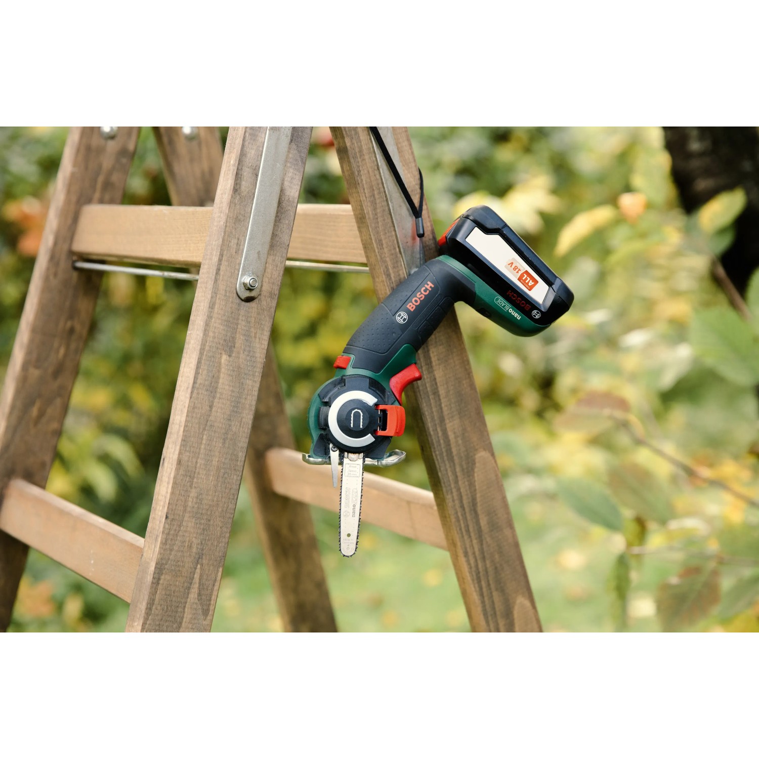 Bosch Akku-Säge AdvancedCut 18 mit Akku auf einer Holzleiter im Garten.