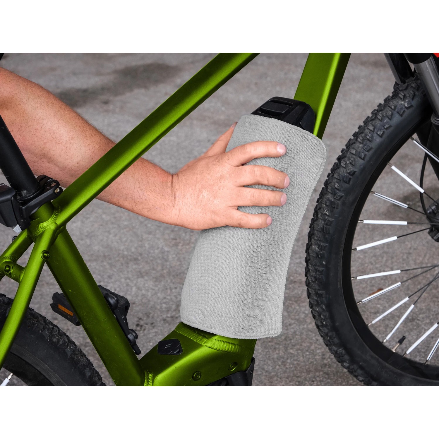 Fahrradpflege: Person reinigt E-Bike mit Tuch. Eufab Pflegeset für Rahmen, Reifen und Kette.