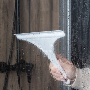 Hand wischt mit weißem Schulte Glaswischer eine Duschkabine ab.