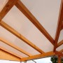 Bronzefarbene Hohlkammerplatte (16 mm) als Terrassenüberdachung auf Holzkonstruktion.
