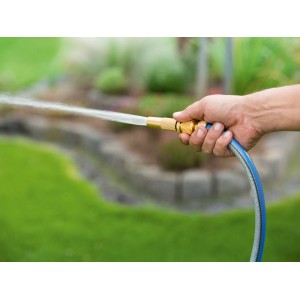 Hand hält LUX Aluminium Anschlussset mit Gartenschlauch und Wasserstrahl.