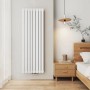 Weißer vertikaler Emke Paneelheizkörper im Schlafzimmer. Moderner Badheizkörper aus Stahl, wandmontiert.
