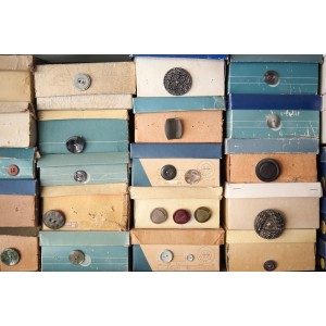 Stapel Schuhkartons mit Knöpfen als Griffen in verschiedenen Farben und Größen.