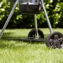 Detailaufnahme: Weber Holzkohle Kugelgrill Master-Touch GBS E-5750 mit Rädern auf Rasen.
