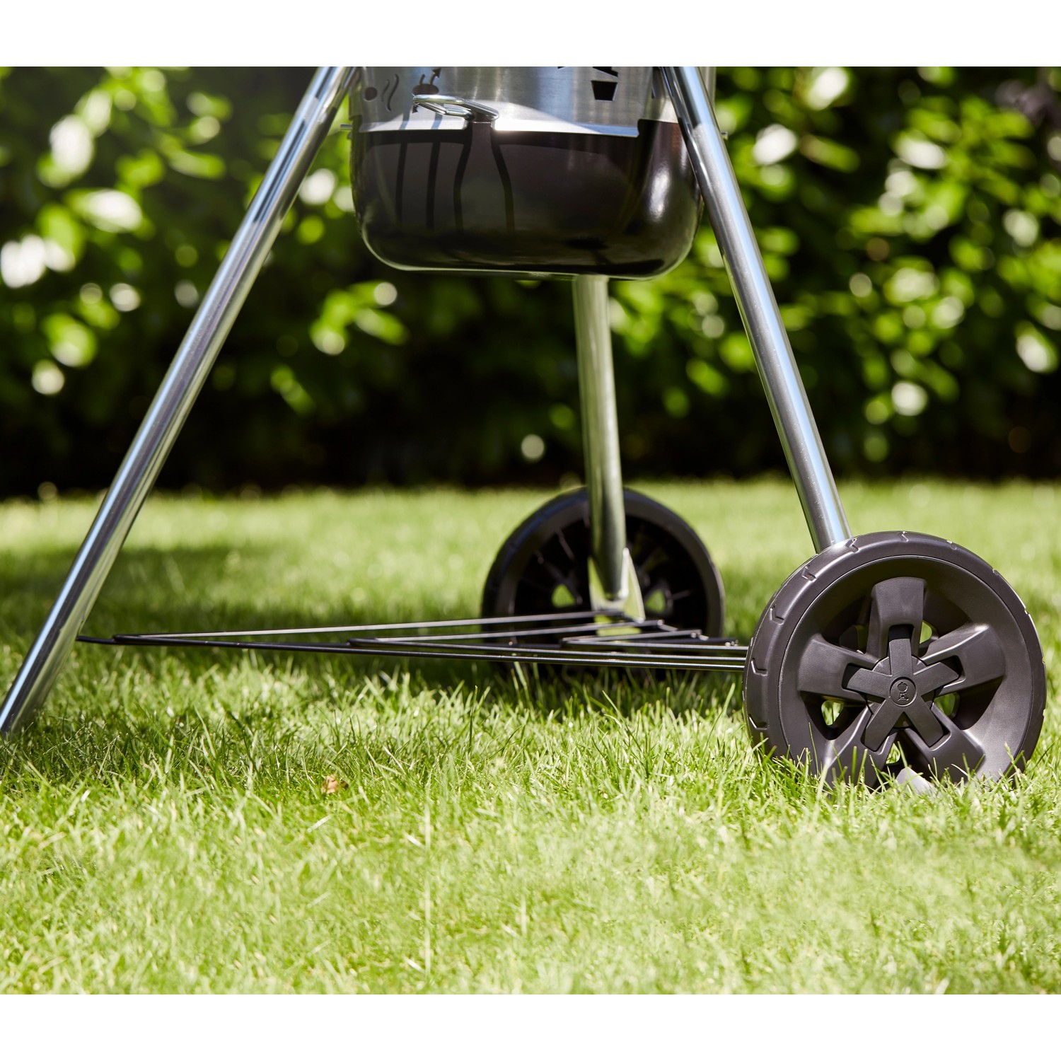 Detailaufnahme: Weber Holzkohle Kugelgrill Master-Touch GBS E-5750 mit Rädern auf Rasen.