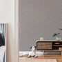 A.S. Création Vliestapete Blätter Grau im Wohnraum mit Hund und Kommode.