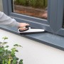 SmartQ Haushalts- & Tapezierbürste im Einsatz zum Reinigen eines Fensterrahmens.