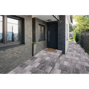 Verlegte, anthrazit-schattierte Terrassenplatten 60x30 cm im Außenbereich vor einem Hauseingang.