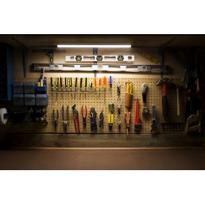LED-Unterbauleuchte Batten Sensor, 120 cm, weiß, montiert über Werkbank mit Werkzeugen.