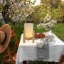 Näve LED-Tischleuchte Madita mit Leinen-Schirm und Holzfuß auf Gartentisch.