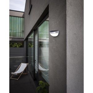 Lutec Solar-Wandleuchte Bubble aus Edelstahl an grauer Hauswand. Moderne Solarleuchte für den Außenbereich.