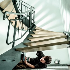Handwerker montiert Treppe mit Metabo Akku-Bohrschrauber BS 18 Solo mit Koffer.