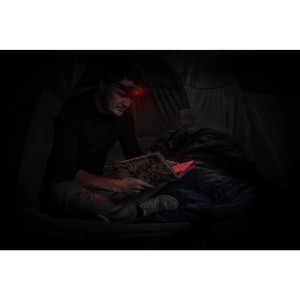 Mann liest im Zelt mit roter Energizer Kopflampe. Universal Headlamp mit 2xAAA Batterien inklusive.