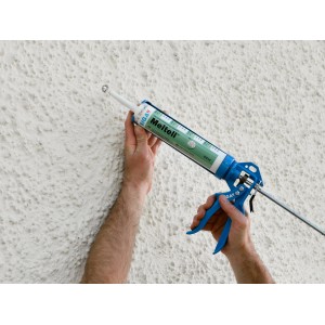 Hände applizieren Siga Meltell 311 Hochleistungsdichtstoff mit Kartuschenpistole auf weiße, strukturierte Wand.