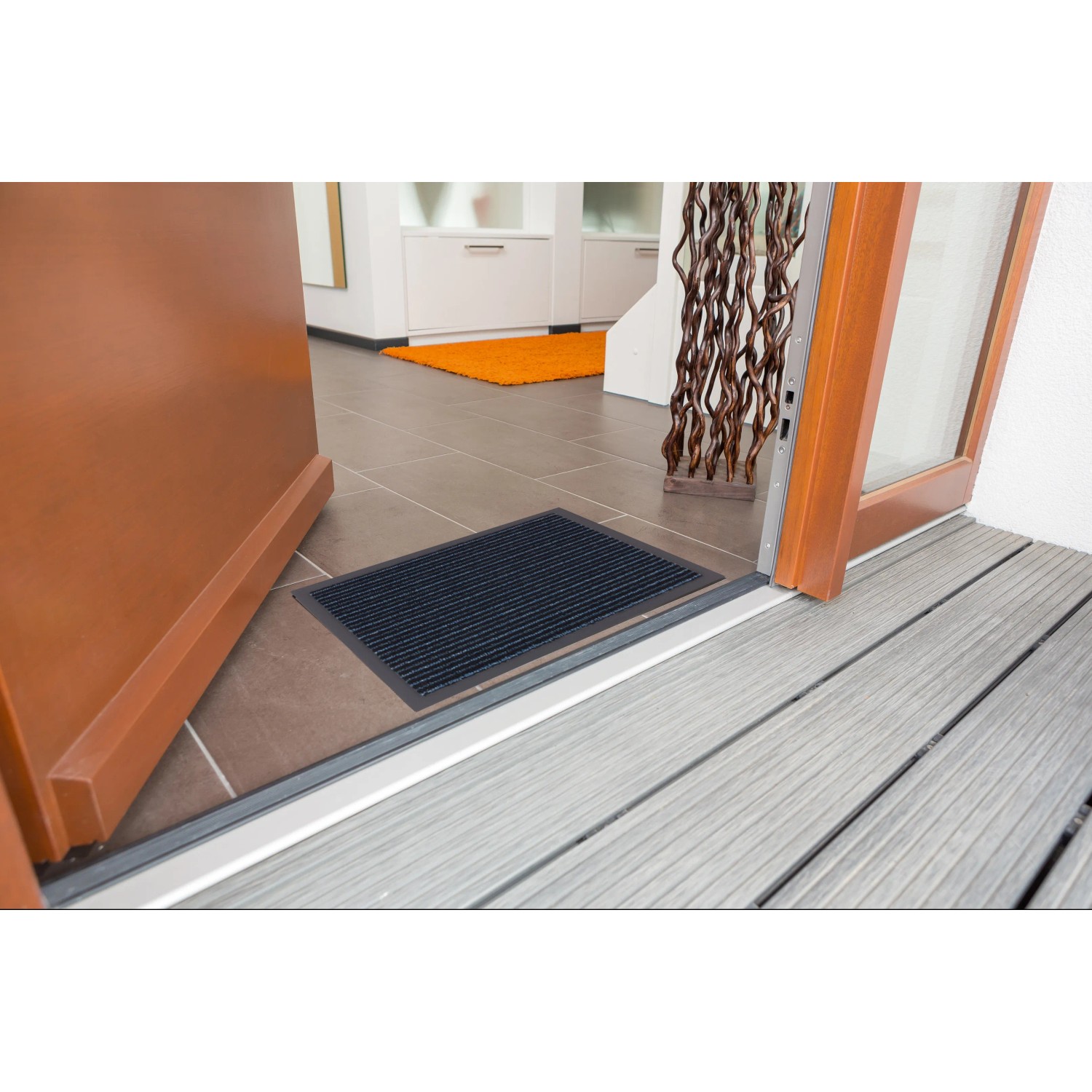 ASTRA Sauberlaufmatte in Jade Blau, 40x60 cm, vor einer Tür. Fußmatte für den Innenbereich.