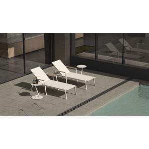 Zwei sandfarbene Best Sonnenliegen Paros mit Teakholz-Armlehnen am Pool.