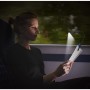 Frau liest mit Energizer Booklight Speziallampe im Zug. LED Leselampe mit flexiblem Hals.