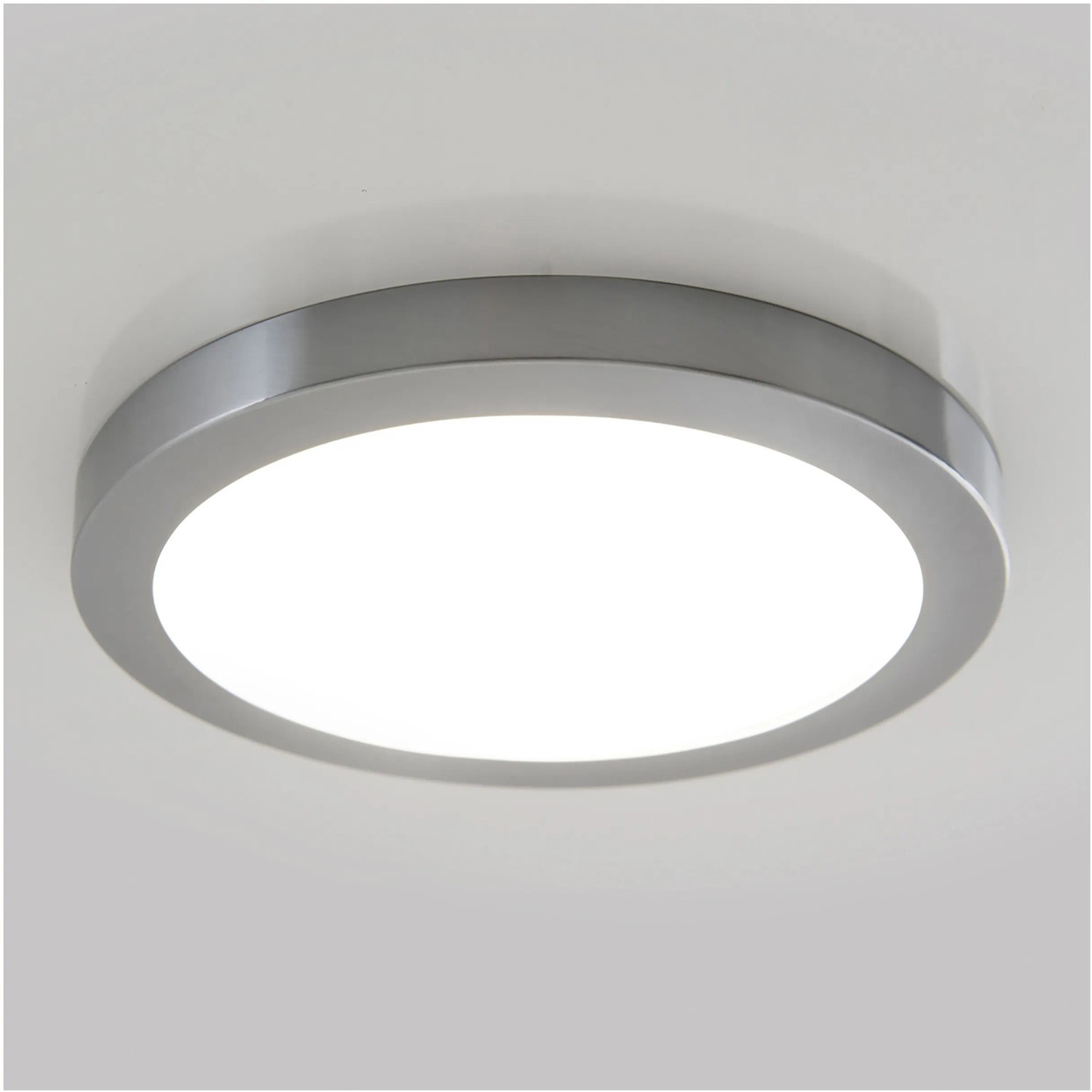 Runde Näve LED-Deckenleuchte Bonus (22,5 cm) mit silbernem Rahmen an weißer Decke.