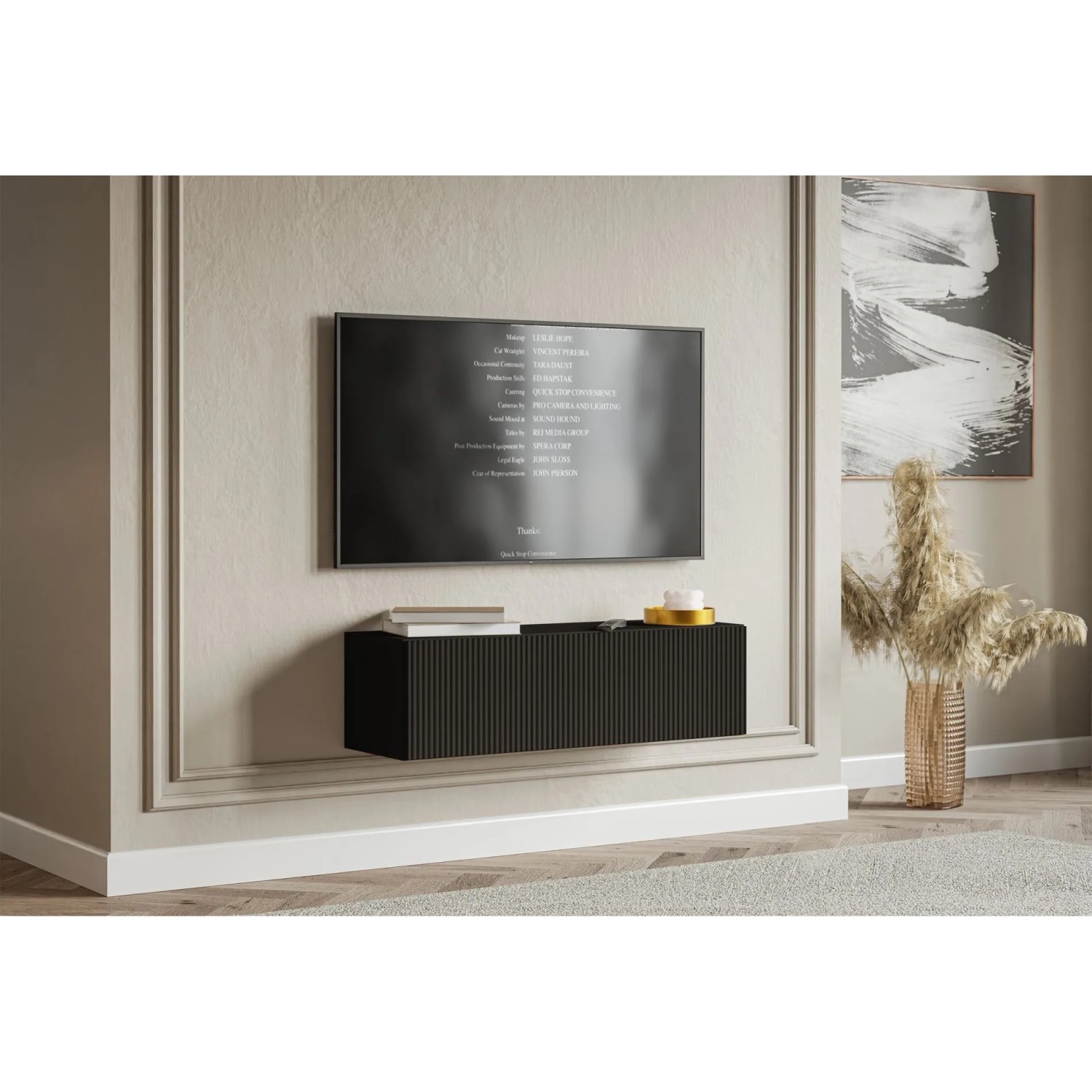 Schwarzes Selsey Veldio TV-Hängeboard mit geriffelter Lamellenfront unter einem Fernseher im modernen Wohnzimmer.