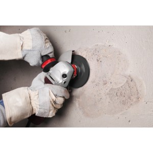 Anwendung des kwb Diamant-Schleiftellers Aggreso-Flex (Ø 12,5 cm) an einer Wand mit Winkelschleifer.