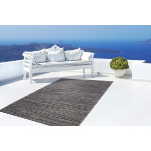 Grauer Outdoor-Teppich Algo 810 (160x230 cm) auf einer Terrasse mit Meerblick.